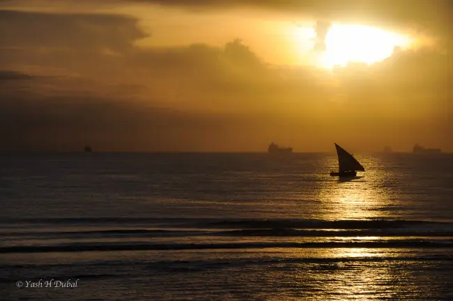 Sunrise at the sea with sail boat floating over the horizon Sunrise at the sea with sail boat floating over the horizon - free high resolution image