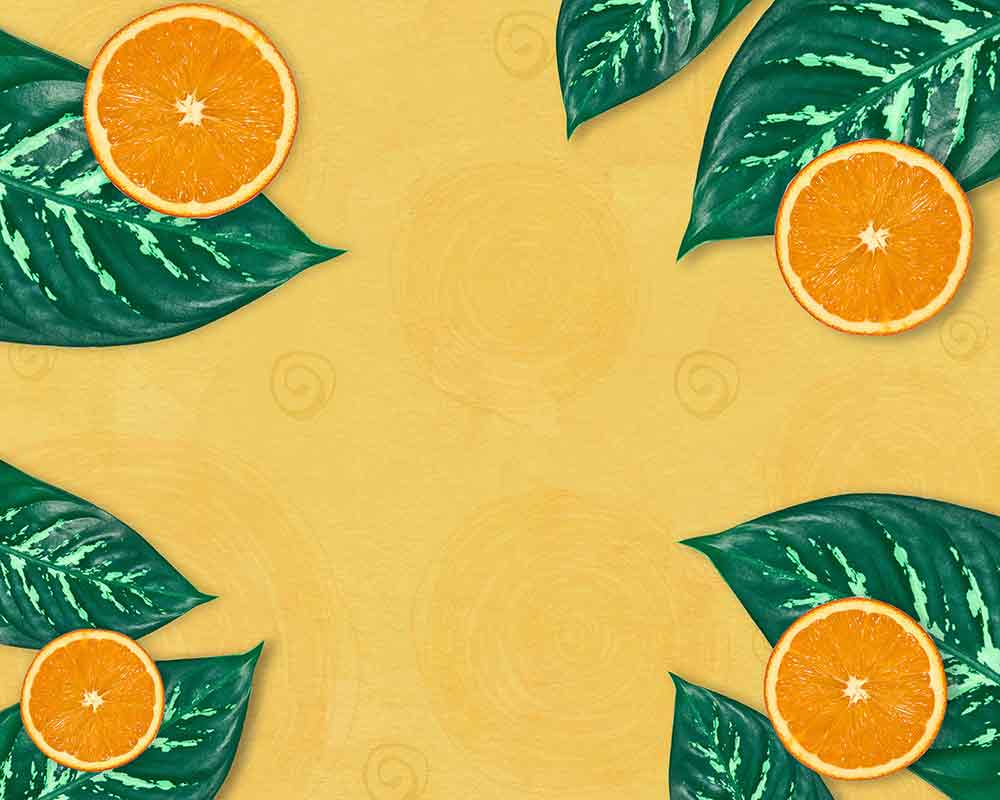 sliced oranges and green leaves on yellow background