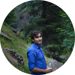 A person standing with mountain in the background