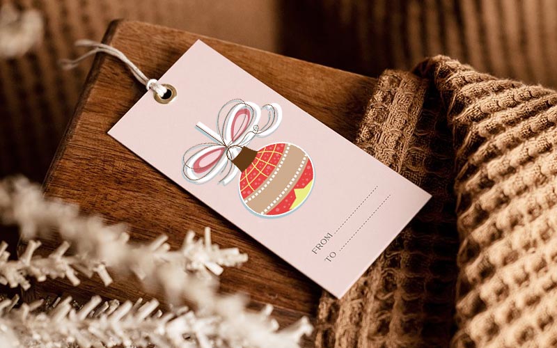 A gift tag with Christmas element on it laying on a table for Christmas Graphics Bundle