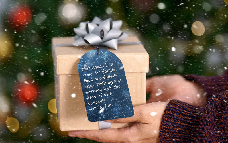 A giftbox with a blue coloured gift tag and a ribbon on top for Christmas Graphics Bundle