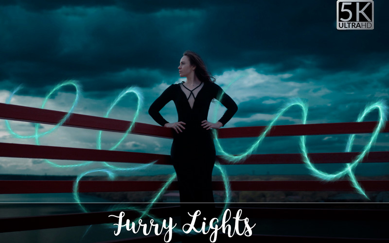 Image of a girl in black dress surrounded by sea-green colored pattern.