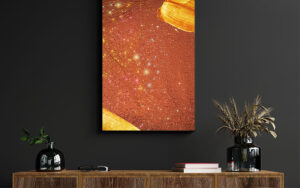 Square framed print on a teal wall reading "Shine BRIGHT" over gold bokeh lights.