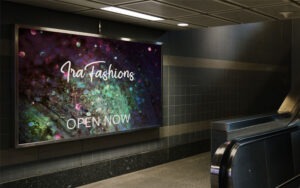 Subway billboard advertising "Ira Fashions" over a dark green and purple glitter background.