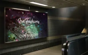 Subway billboard advertising "Ira Fashions" over a dark green and purple glitter background.