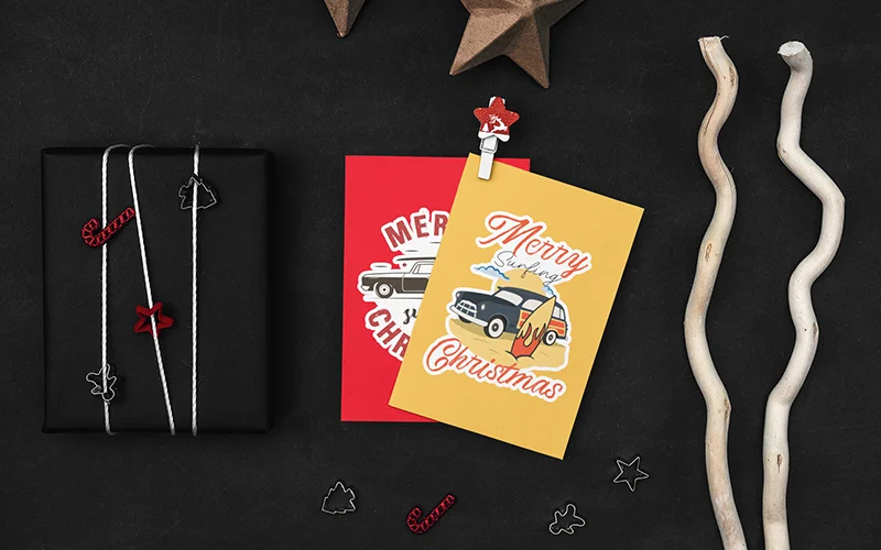 mockup of two postcards surrounded by christmas themed supplies