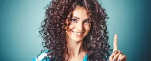 Woman with curly hair cleanly extracted and placed on a solid teal background after using AI edge detection in CutOut 11.