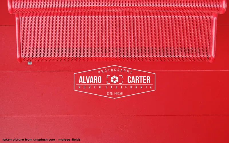 Minimal red wall with a white vintage photography badge logo design reading Alvaro Carter Photography, North California.