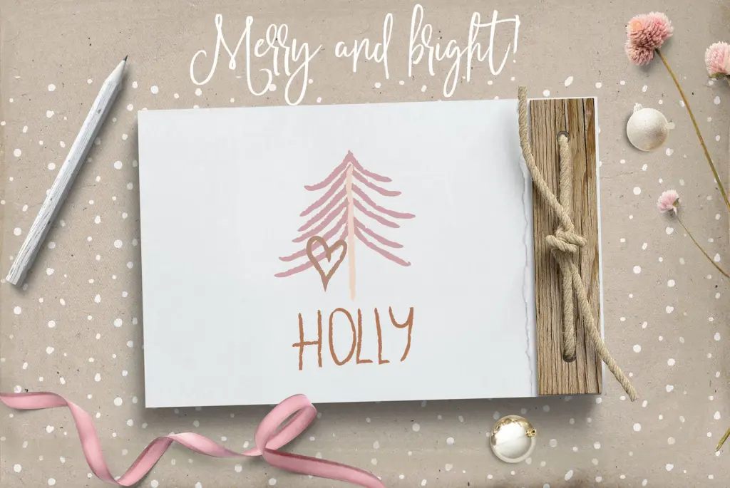 A flat lay shows a drawing of a pink Christmas tree with a heart and the word "HOLLY."