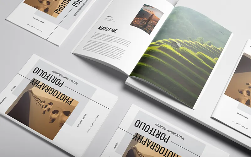 Multiple white photography portfolio books, some open and some closed, displaying nature scenes and text.