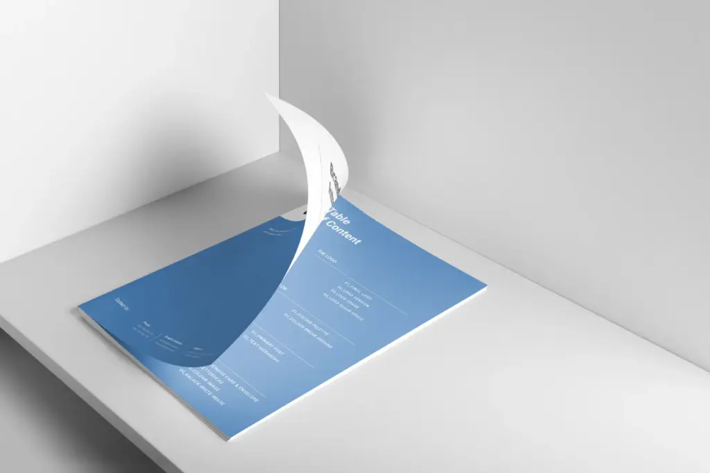 Close-up of a document mock-up focusing on the blue back cover/Table of Content page, partially peeled back.