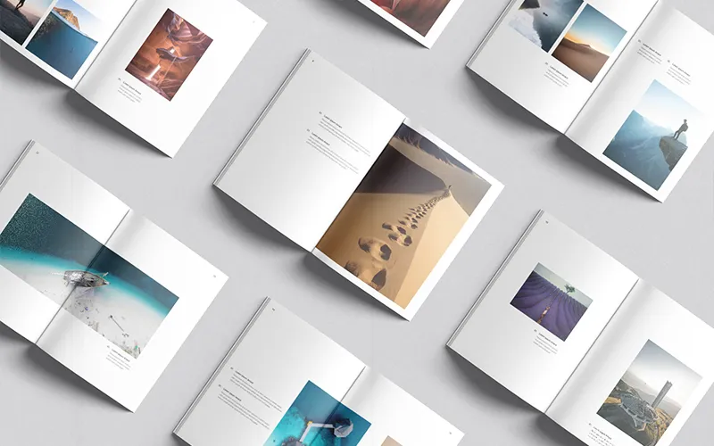 Grid of open photobooks with diverse landscapes and clean, centered captions