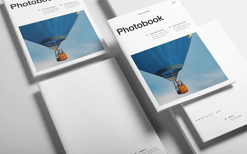 Photobook stack with hot air balloon cover and themed sections like Summer Memories and Nature Escapes