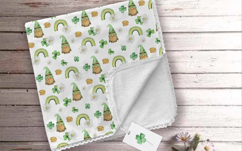 A white cloth napkin featuring a repetitive St Patricks Day pattern of gnomes, rainbows, and gold coins.