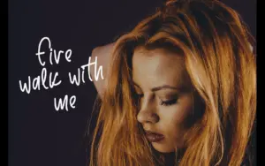 A close-up of a woman with red hair featuring the text "fire walk with me" in a free handwritten script font.