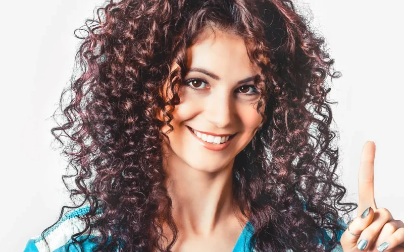 Woman with curly hair against a clean white background before using AI edge detection in CutOut 11.